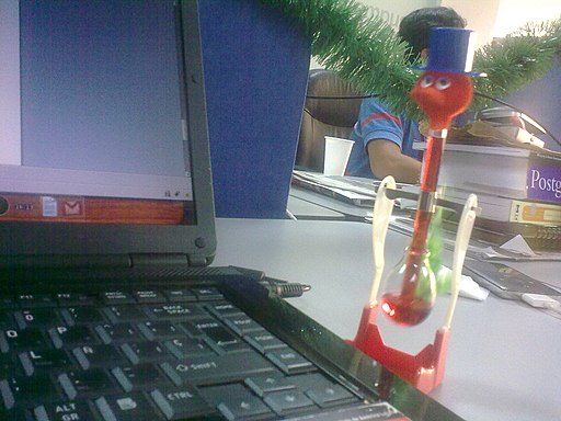 Drinking bird in front of laptop