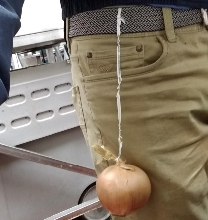 A photo of a person wearing an onion tied around their belt.