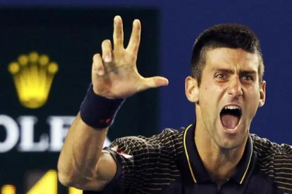 A male tennis player holding up a thumb and two index fingers while screaming