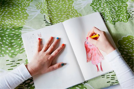 A picture of a drawing pad with a child's drawing of a girl on one side and practice words on the other. 