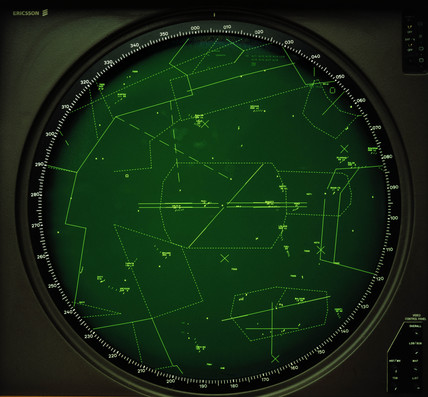 An old, green, monochrome air traffic control radar screen centered on an airport
