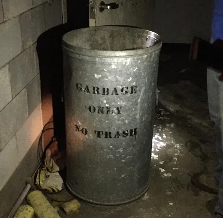 A garbage can with the stenciled message: "GARBAGE ONLY NO TRASH"